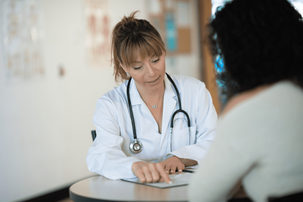 Female doctor checking patient's pulse during consultation.