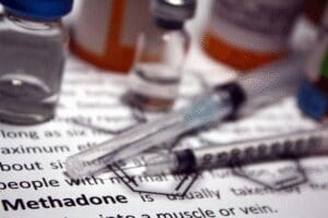 Syringes and bottles of methadone, an FDA-approved medication for MAT/ MOUD treatment.