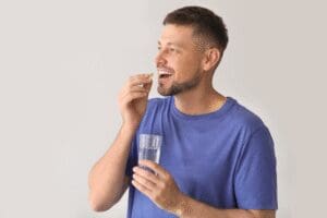 A man taking medication, illustrating that MAT and MOUD are effective addiction treatment protocols