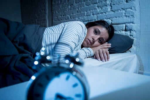 Lady awake in bed, as could happen due to sleep problems from methadone.