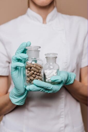 Medical personnel holds two containers of pills, one being Methadone and the other Buprenorphine