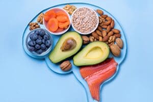 Healthy foods arranged in a brain-like formation. Exercise and nutrition are key to addiction recovery.