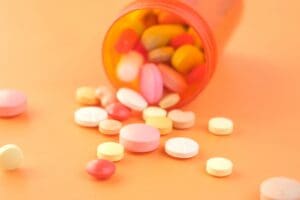 Pills spilling out a bottle, as may happen when navigating the opioid withdrawal timeline.