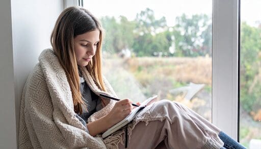 Woman writing in her journal as part of her relapse prevention strategies.
